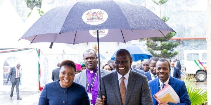 President William Ruto (right) holds the umbrella for Health CS Susan Nakhumicha while making their way to Syokimau, Machakos County on November 22, 2023.