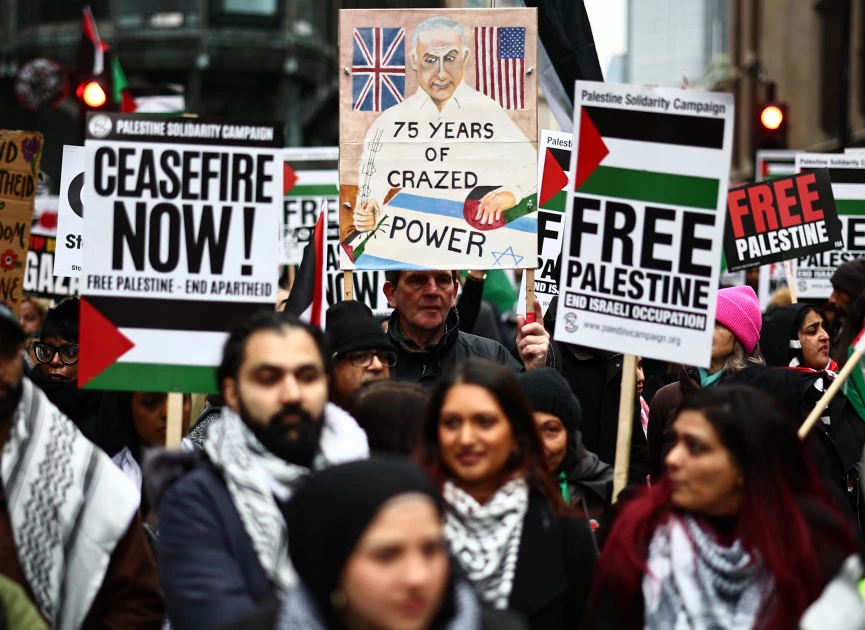 Pro-Palestinian activists and supporters wave flags and carry placards during a National March for Palestine in central London on January 13, 2024. (Photo by HENRY NICHOLLS / AFP)