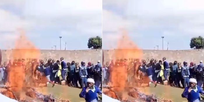 Parents and students from Mawingu Primary School torch down a fence.