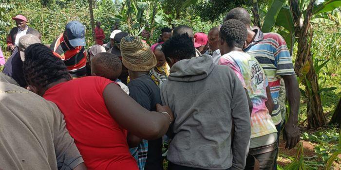 Curious onlookers looking over at the body of a woman dumped at a coffee plantation in Kirinyaga County