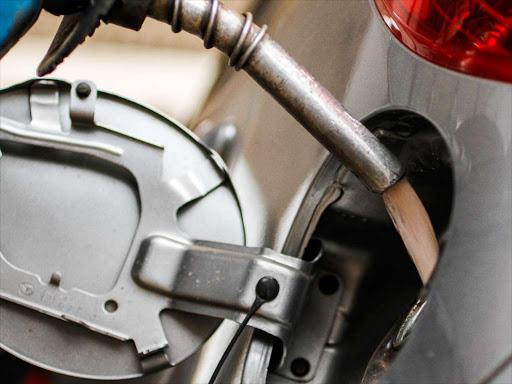 PAIN AT THE PUMP: An attendant fills up a car at a petrol station.