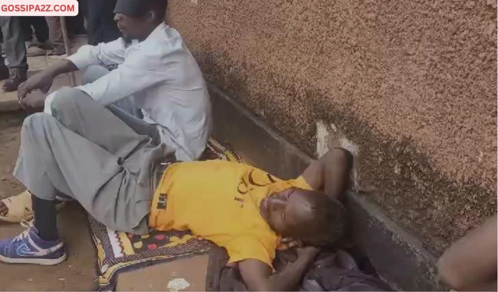 Two of the men who reportedly went blind after consuming illicit liquor in Kirinyaga sit outside a house on Tuesday, February 06 as a crowd gather.