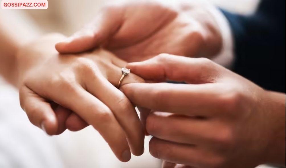 A photo of a couple exchanging wedding rings.