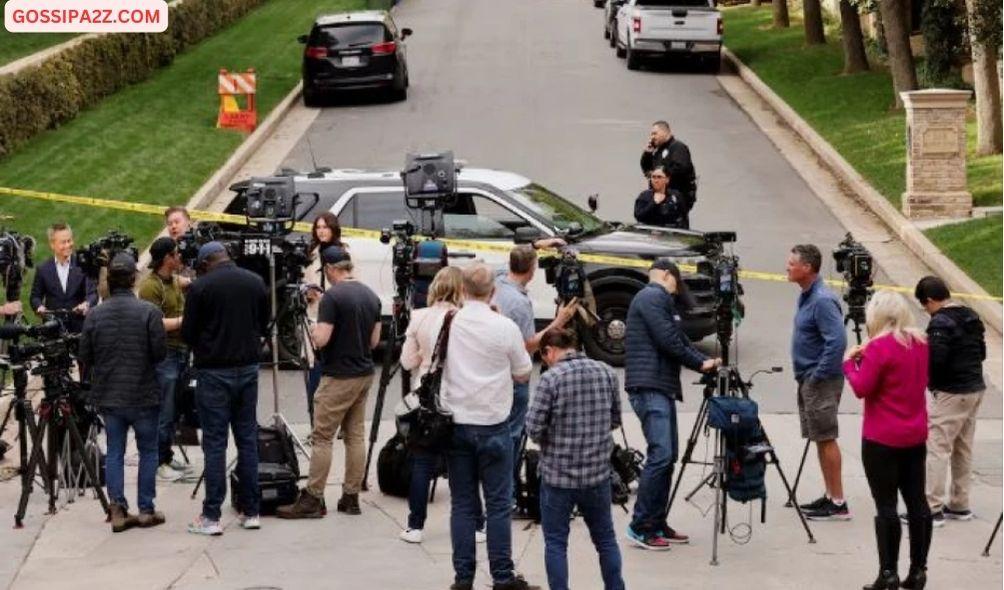 Media members work as law enforcement officers stand behind police tape outside a property connected to hip-hop star Sean 