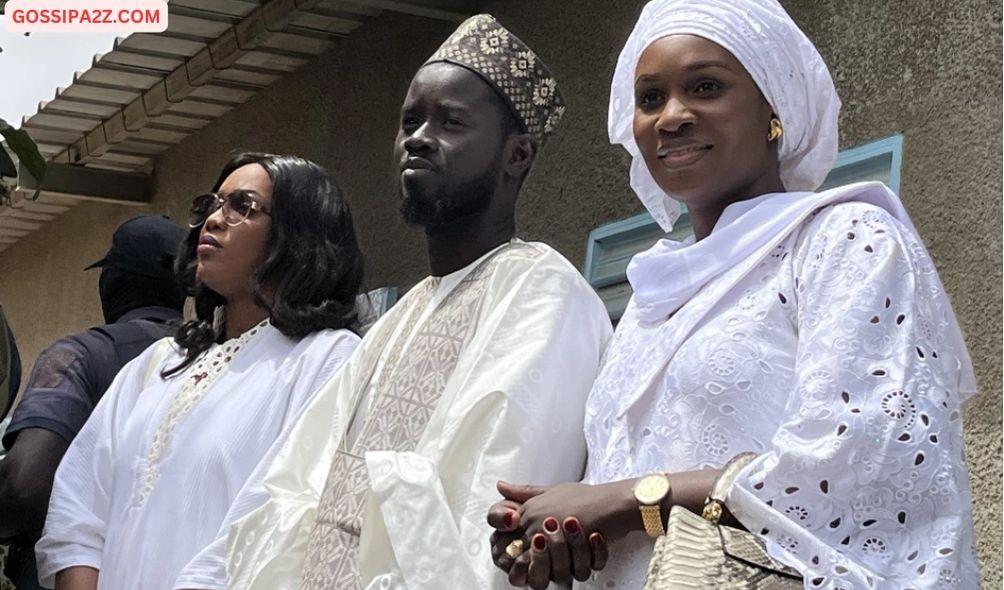 Presidential candidate for the Diomaye President coalition Bassirou Diomaye Faye (C), and his wives Marie Khone Faye (L) and Absa Faye (R) looks on after casting their ballots at the École Ndiandiaye polling station in Ndiaganiao on March 24, 2024 during Senegal's presidential elections. (Photo by Khadidiatou Sene / AFP)