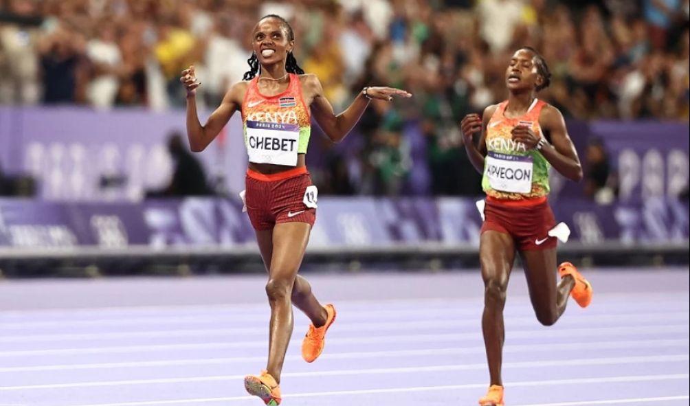 Kenya's Beatrice Chebet crosses the finish line ahead of Kenya's Faith Kipyegon in the women's 5000m final of the athletics event at the Paris 2024 Olympic Games at Stade de France in Saint-Denis, north of Paris, on August 5, 2024. (Photo by Anne-Christine POUJOULAT / AFP)