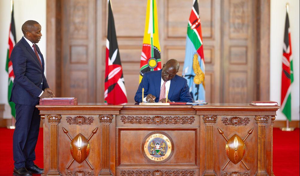 President William Ruto assents to the Division or Revenue Bill as National Assembly clerk Samuel Njoroge looks on during the event at State House on December 4, 2024